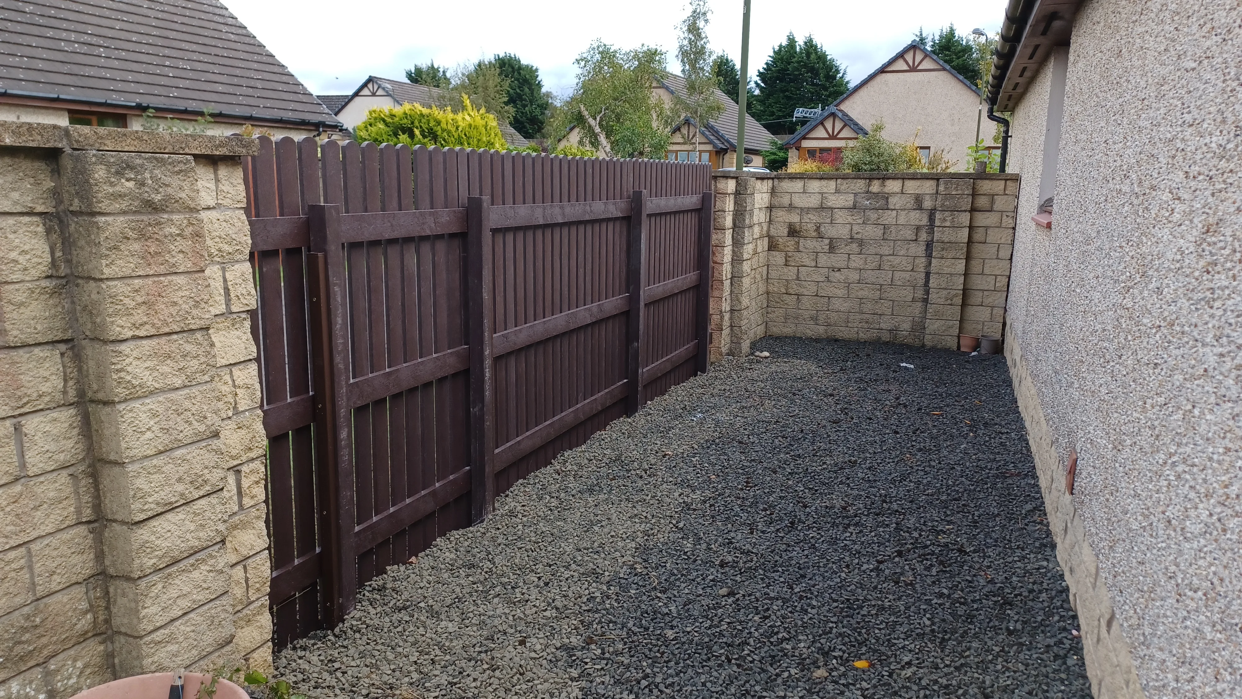 Brown recycled plastic fence installed with posts and boards in residential setting