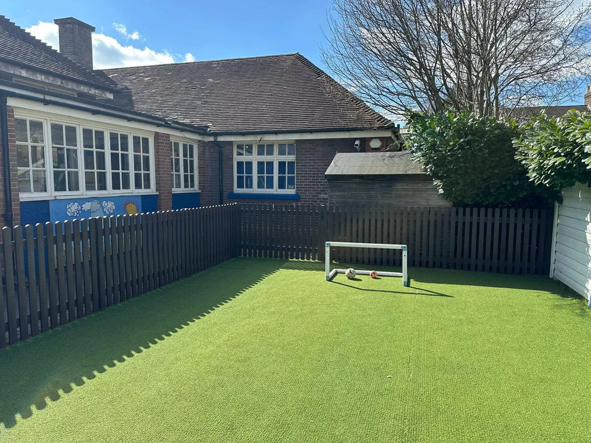 School playground view with charcoal recycled plastic fence and artificial grass
