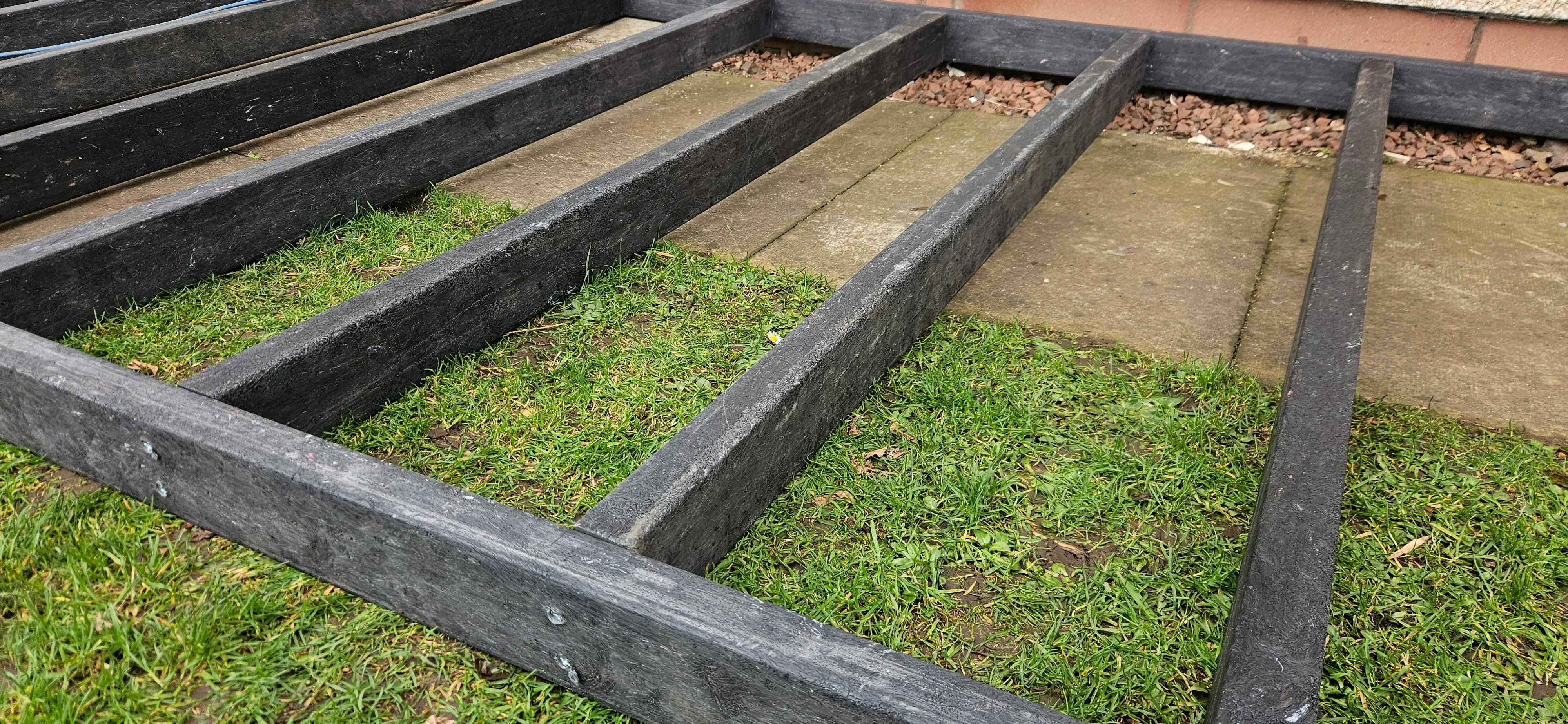 Close-up of black recycled plastic decking joists installed on patio