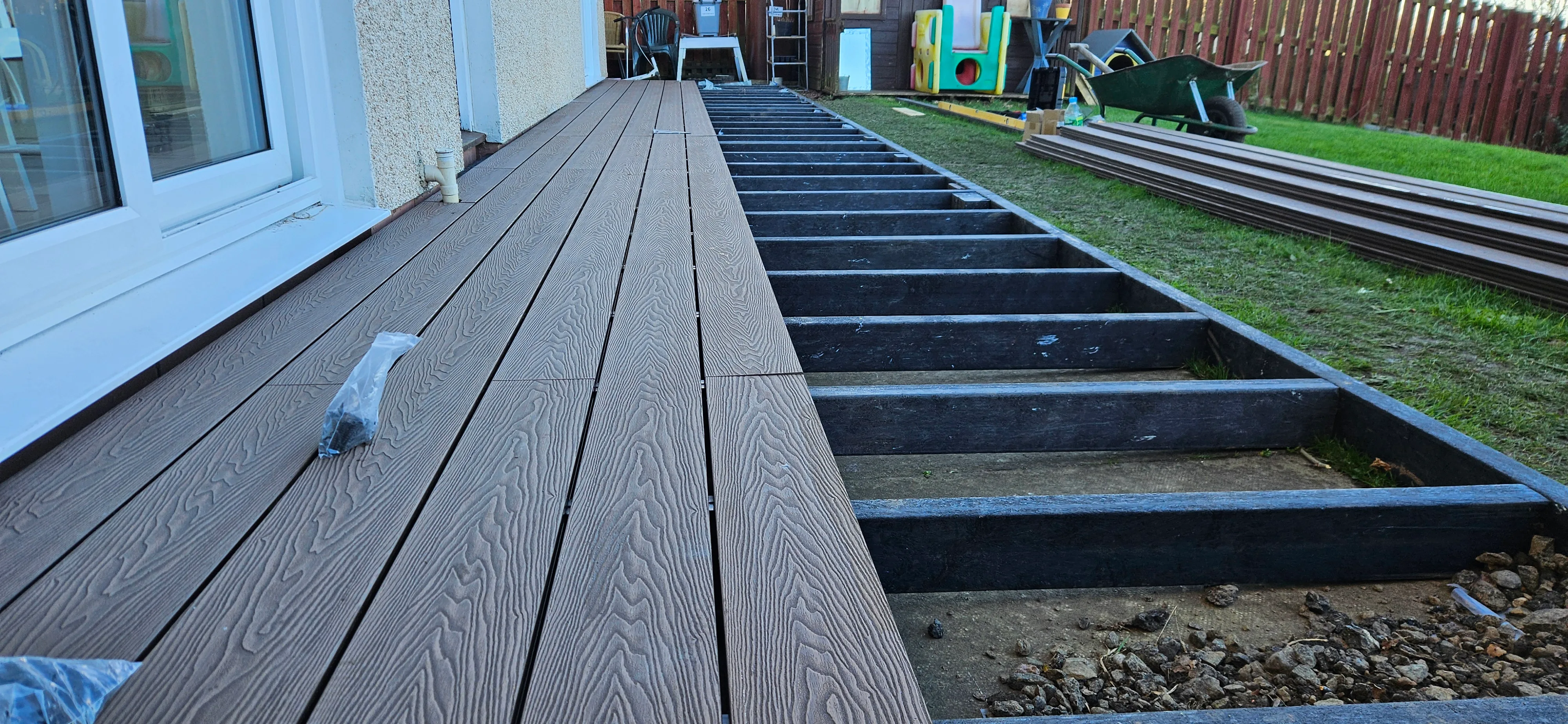 Decking project half complete showing black recycled plastic subframe