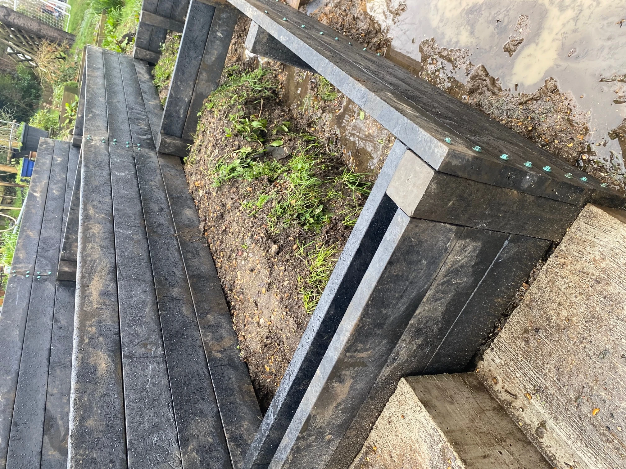 Retaining wall showing soil pressure management with recycled plastic